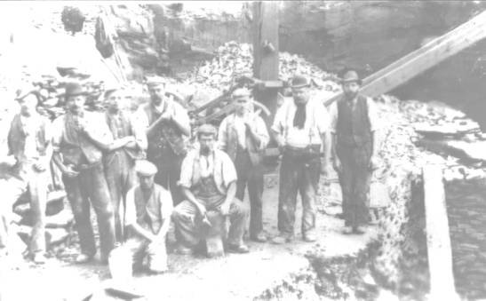 faded photograph of nine workmen (in a quarry?)(source unknown).